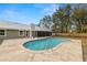 An in-ground pool is surrounded by a concrete deck in this verdant backyard at 4550 Old Colony Rd, Mulberry, FL 33860