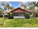 A sunroom/screened-in patio area with a well-maintained lawn and mature trees and bushes at 4613 Little Grove Ln, Lakeland, FL 33813