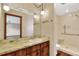 Bathroom features a tiled shower, marble countertop, and warm lighting, offering a bright and clean space at 4613 Little Grove Ln, Lakeland, FL 33813