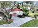 A side view of the home, with a garage, long driveway, and mature trees at 4613 Little Grove Ln, Lakeland, FL 33813