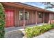 Charming home exterior with a red front door, wood siding and meticulously landscaped yard at 4613 Little Grove Ln, Lakeland, FL 33813