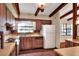 Cozy kitchen features wood cabinets, brick flooring, and lots of natural light from a large window at 4613 Little Grove Ln, Lakeland, FL 33813