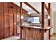 Cozy kitchen featuring wood cabinets, stainless steel appliances, and a bar with a view to living area at 4613 Little Grove Ln, Lakeland, FL 33813