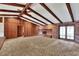 Spacious living room featuring a brick fireplace, beamed ceiling, and wood paneled wall at 4613 Little Grove Ln, Lakeland, FL 33813