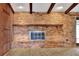 Close up of spacious living room with brick fireplace and a wall of wood paneling at 4613 Little Grove Ln, Lakeland, FL 33813