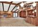 Spacious living room featuring a brick fireplace, beamed ceilings, and a unique wagon wheel chandelier at 4613 Little Grove Ln, Lakeland, FL 33813