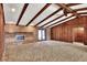 Spacious living room featuring a brick fireplace, beamed ceiling, and wood paneled wall at 4613 Little Grove Ln, Lakeland, FL 33813