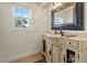 Elegant bathroom vanity with a marble countertop, decorative mirror, and natural light from the window at 4624 Kings Point Ct, Lakeland, FL 33813