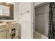 Well-lit bathroom showcasing vanity with a decorative mirror and a walk-in shower with patterned tile at 4624 Kings Point Ct, Lakeland, FL 33813