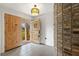 Inviting entryway features a brick wall accent and an ornate light fixture above the tiled floor at 4624 Kings Point Ct, Lakeland, FL 33813