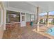 A covered outdoor patio next to the pool with brick flooring, perfect for relaxation at 4624 Kings Point Ct, Lakeland, FL 33813