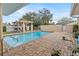 Private backyard pool with lush landscaping, brick pavers, shaded pergola and privacy fence at 4624 Kings Point Ct, Lakeland, FL 33813