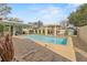 Sparkling pool area with brick pavers, lush landscaping, shaded pergola and privacy fence, perfect for relaxation at 4624 Kings Point Ct, Lakeland, FL 33813