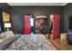 Bedroom with red doors, bed with floral pattern, dark walls, and open closets at 477 Kensington View Dr, Winter Haven, FL 33880