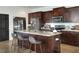 Kitchen island with stainless steel appliances, brown cabinetry and granite countertops at 477 Kensington View Dr, Winter Haven, FL 33880