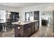 Kitchen island with a double sink and stainless steel dishwasher with dining table in the background at 477 Kensington View Dr, Winter Haven, FL 33880