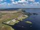 Aerial view of a waterfront property with a metal roof, a detached garage, and its surrounding neighborhood at 5418 Cooper Ln, Fort Meade, FL 33841