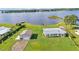 Aerial view of waterfront homes, a lush lawn, and a detached garage, all near a scenic lake at 5418 Cooper Ln, Fort Meade, FL 33841