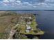 Stunning aerial view showcases a lakefront home with sprawling grounds and dock, offering serene waterfront living at 5418 Cooper Ln, Fort Meade, FL 33841