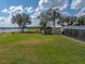 Lush, green backyard with a screened lanai, outdoor grilling area, and views of the tranquil lake at 5418 Cooper Ln, Fort Meade, FL 33841