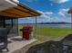 A red grill sits outside the screened patio, overlooking the lawn and lake at 5418 Cooper Ln, Fort Meade, FL 33841