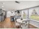 Open-concept dining area with a white table and chairs, seamlessly flowing into the kitchen with a breakfast bar at 5418 Cooper Ln, Fort Meade, FL 33841