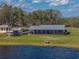 An exterior view of the house and detached garage from across the lake at 5418 Cooper Ln, Fort Meade, FL 33841