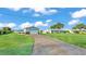 Exterior view of home featuring a spacious driveway leading to a garage and a well-maintained lawn at 5418 Cooper Ln, Fort Meade, FL 33841