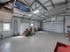 Spacious garage with epoxy floor, overhead door, and multiple ride on mowers at 5418 Cooper Ln, Fort Meade, FL 33841