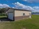 A two-toned detached garage sits on a lush lawn, with the lake in the background at 5418 Cooper Ln, Fort Meade, FL 33841