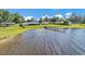 Scenic waterfront view featuring a private dock extending into the lake with lush greenery around the property at 5418 Cooper Ln, Fort Meade, FL 33841