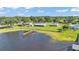 Picturesque waterfront property with a dock leading into a serene lake, surrounded by well-kept green lawns and trees at 5418 Cooper Ln, Fort Meade, FL 33841