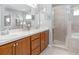 Bathroom with double sink vanity, framed mirrors, and a walk-in shower at 5443 Se 127Th Ln, Belleview, FL 34420