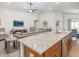 Kitchen view with a granite countertop island, stainless steel appliances, and seamless flow to living and dining areas at 5443 Se 127Th Ln, Belleview, FL 34420