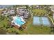 Aerial view of a community center featuring a pool, tennis courts, playground, clubhouse, and parking area at 5623 Superior Dr, Lakeland, FL 33805