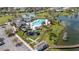 Aerial view of a community recreation area featuring a pool, clubhouse, and playground near a tranquil lake at 5623 Superior Dr, Lakeland, FL 33805