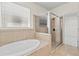 Bathroom featuring a soaking tub and glass-enclosed shower at 5623 Superior Dr, Lakeland, FL 33805