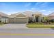 Inviting exterior featuring a three-car garage, lush front yard, and neutral color palette at 5623 Superior Dr, Lakeland, FL 33805