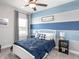 Comfortable bedroom features a blue accent wall, a ceiling fan, and a side table at 567 Silver Course Radl, Ocala, FL 34472