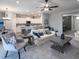 Open-concept living room with ceiling fan and neutral decor flows into kitchen and dining areas at 567 Silver Course Radl, Ocala, FL 34472