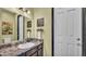 Well-lit bathroom with a large mirror, marbled countertop and dark wood cabinets at 5806 Valentino Way, Lakeland, FL 33812