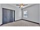 Bedroom featuring gray walls, dark trim, a ceiling fan and closet with bi-fold doors at 5806 Valentino Way, Lakeland, FL 33812