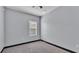 Neutral bedroom featuring gray walls, dark trim, and a window with blinds at 5806 Valentino Way, Lakeland, FL 33812