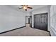 Bedroom with gray carpet, ceiling fan, and black trim and closet doors at 5806 Valentino Way, Lakeland, FL 33812