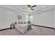 Cozy bedroom with tray ceilings, carpeted floors, and bright window lighting at 5806 Valentino Way, Lakeland, FL 33812