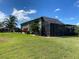 Exterior view of the home, including screened lanai and lush landscaping at 585 Meandering Way, Polk City, FL 33868