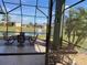 Covered screened-in patio overlooking the lake with additional seating at 585 Meandering Way, Polk City, FL 33868