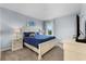 Serene bedroom featuring a queen-sized bed with blue bedding, side tables, and natural light at 6160 Broad Oak Dr, Davenport, FL 33837