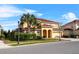 Charming two-story home featuring a tile roof, arched entryway, and lush landscaping at 6160 Broad Oak Dr, Davenport, FL 33837