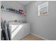 Well-lit laundry room with window and storage shelf, with washer and dryer at 6160 Broad Oak Dr, Davenport, FL 33837